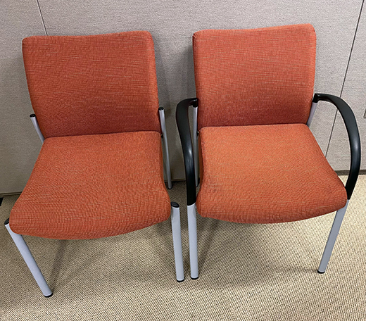 Two adobe-colored cushioned chairs with light gray metal legs, one with arms and one without.